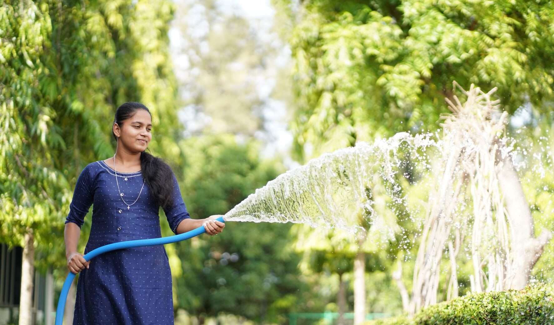 Renosha, o fată din Sri Lanka, udând grădina