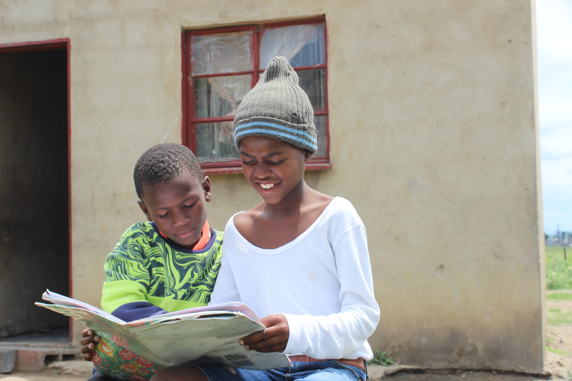 Grace’s kids reading outside their home