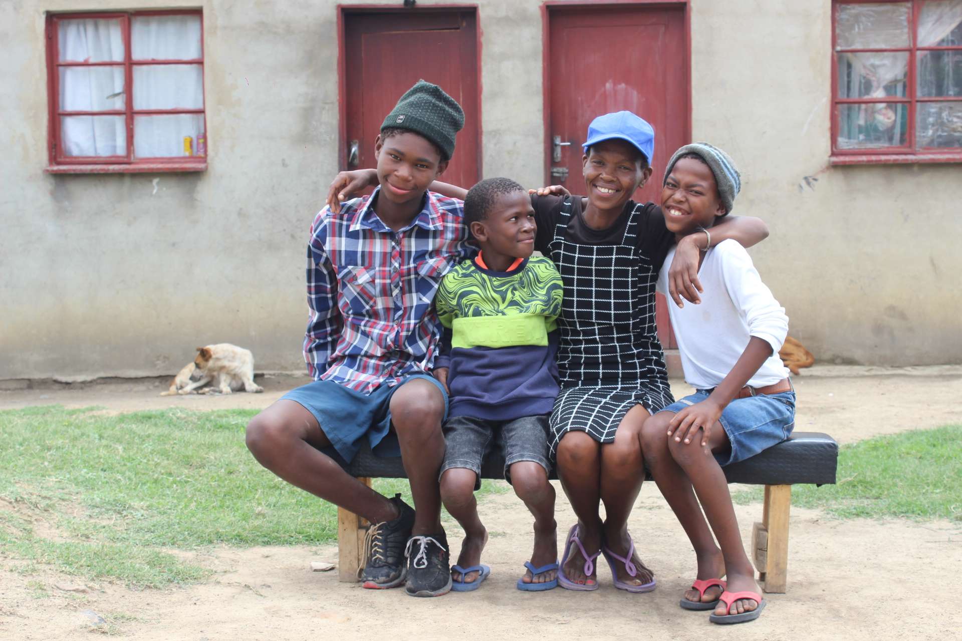 Grace sits with her kids outside their home