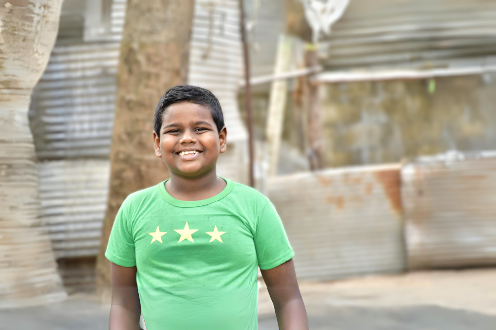 boy in Sri Lanka with green shirt smiling big